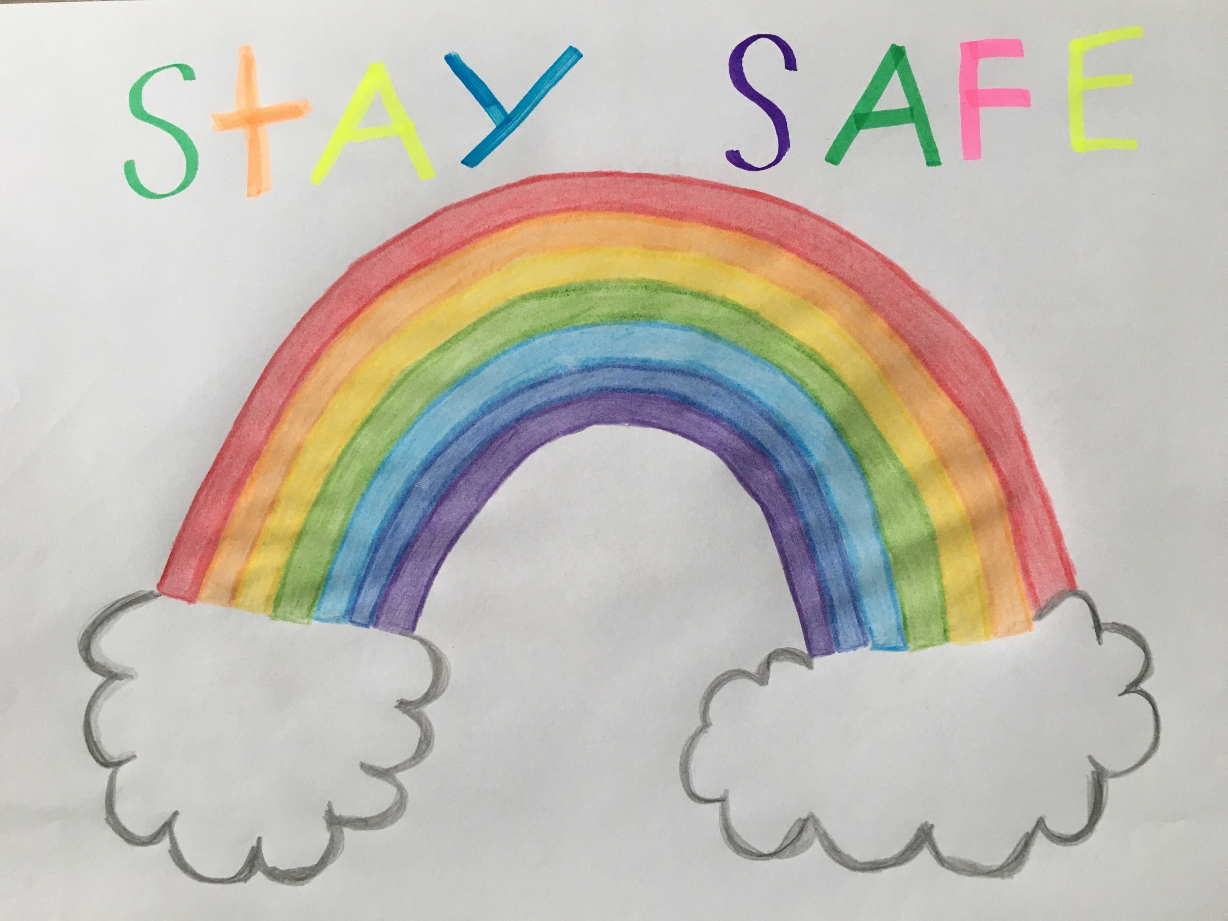 Children's drawing of a rainbow with the words 'stay safe' written above it